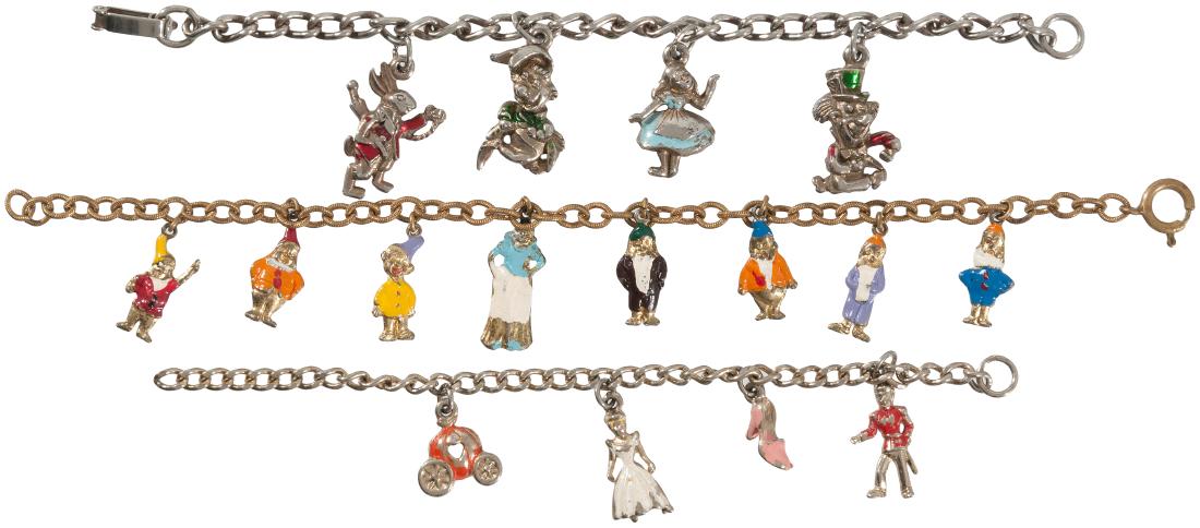 SNOW WHITE AND THE SEVEN DWARFS/CINDERELLA/ALICE IN WON: Lot of three chain link bracelets, measuring between 5.5" and 7.5" long. Snow White bracelet has eight painted gold metal charms, each approx. .75" tall. c. 1938. Cinderella bracelet has four silver m