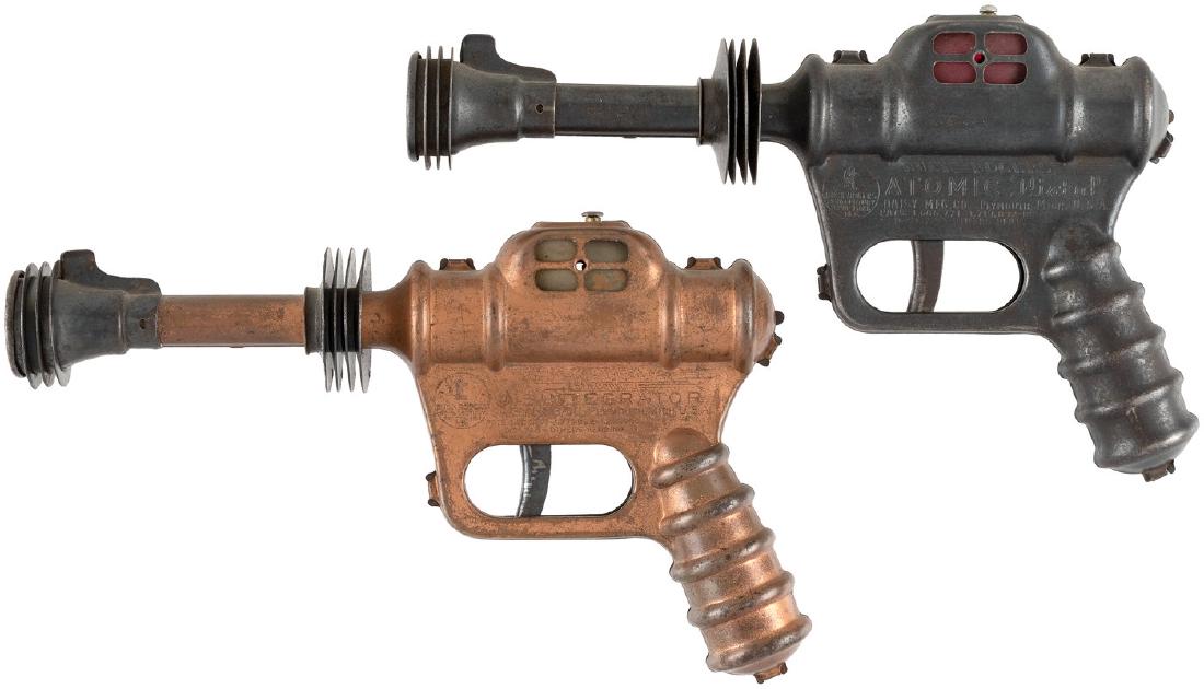 "BUCK ROGERS ATOMIC PISTOL/DISINTEGRATOR" DAISY GUN: BUCK ROGERS ATOMIC PISTOL/DISINTEGRATOR DAISY GUN PAIR. Pair of 9.5" long nice quality metal guns by Daisy Mfg. Co. 1935. "Buck Rogers Atomic Pistol U-235" is in black finish (also released in silver