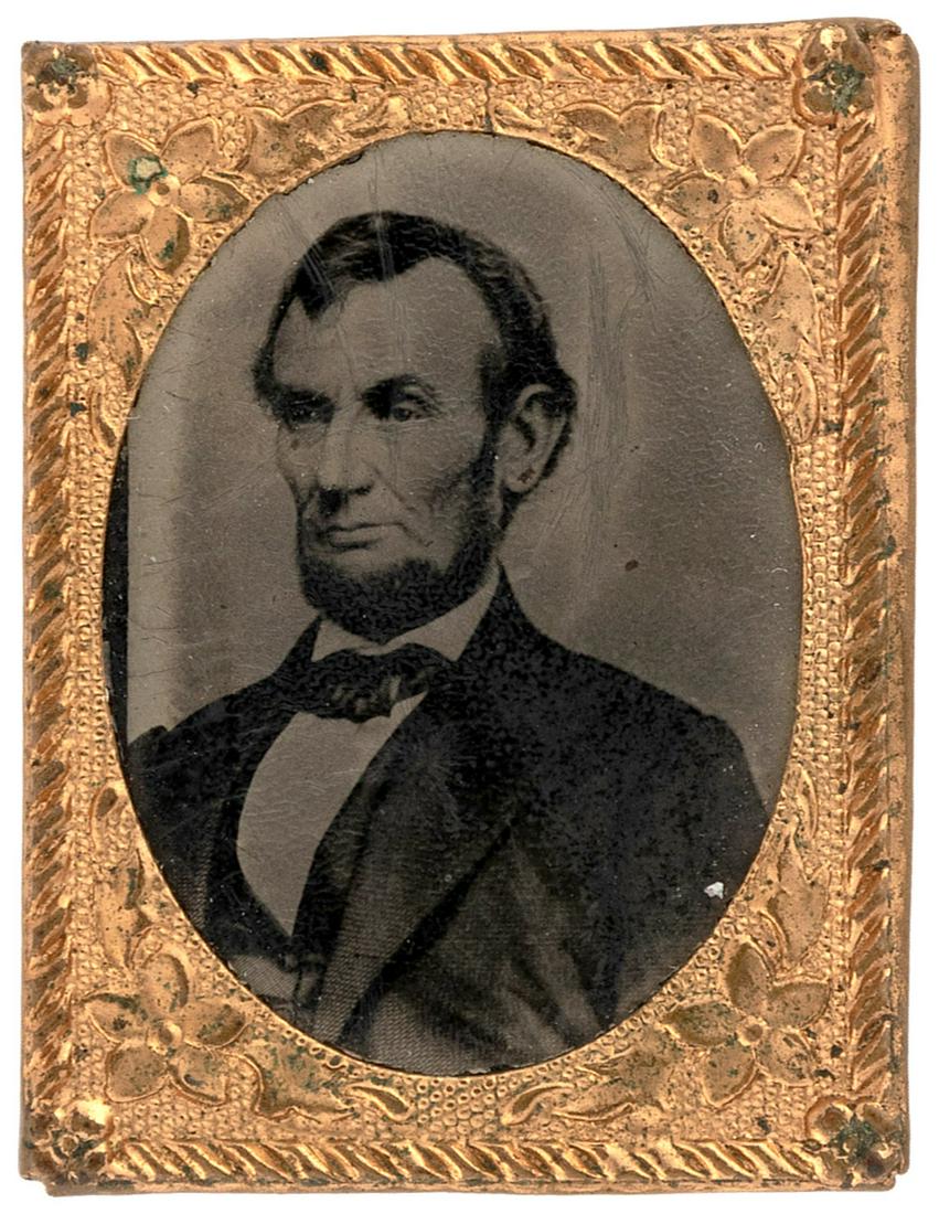 LINCOLN 1864 FIVE DOLLAR BILL POSE GEM FERROTYPE: 3/4x1" (21x28mm) tall. Brass frame has light wear at corners. Image has crazing and hairline scratches to emulsion but no bubbling. Fine. Always among the most popular images of the 16th President.
