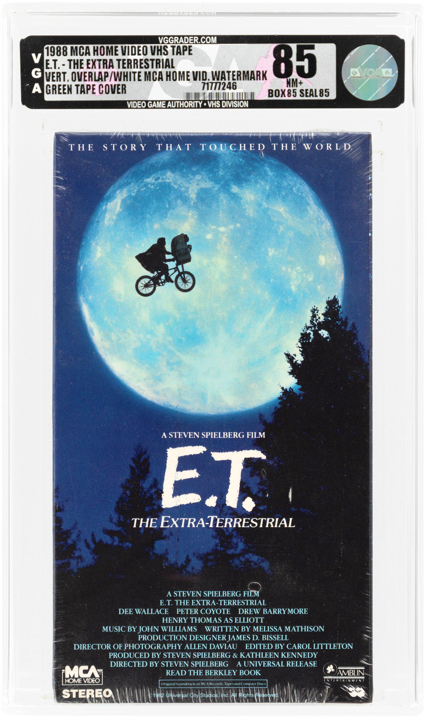 E.T. THE EXTRA-TERRESTRIAL VHS (1988) VGA 85 NM+ (VERTICAL OVERLAP/WHITE MCA HOME VIDEO: MCA Home Video VHS tape for Steven Spielberg's blockbuster 1982 film starring Dee Wallace, Henry Thomas, Peter Coyote, Robert MacNaughton, Drew Barrymore and Erika Eleniak. The film would go on to bec