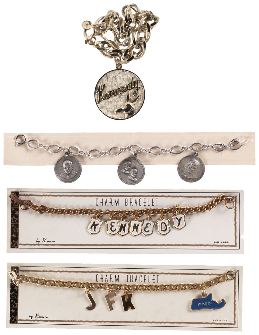 KENNEDY QUARTET OF CHARM BRACELETS INC. THREE ON ORIGINAL SALE CARDS.: Bracelet chains are each about 7" long. Sales cards are 1x8" to 2x7.25". First bracelet features large charm w/"Kennedy" and a relief donkey on it. Second features three charms. Left to right: JFK, hi
