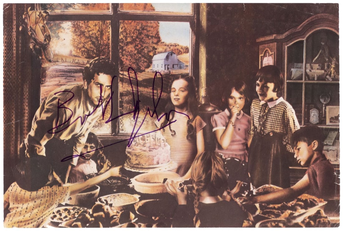 BOB DYLAN SIGNED BOOK PAGE.: 7-7/8x11.75" page from the 1976 book Rock Dreams by writer Nik Cohn and artist Guy Peellaert. Page is one of four Bob Dylan illustrations within the book and shows Dylan leaning over a birthday cake.