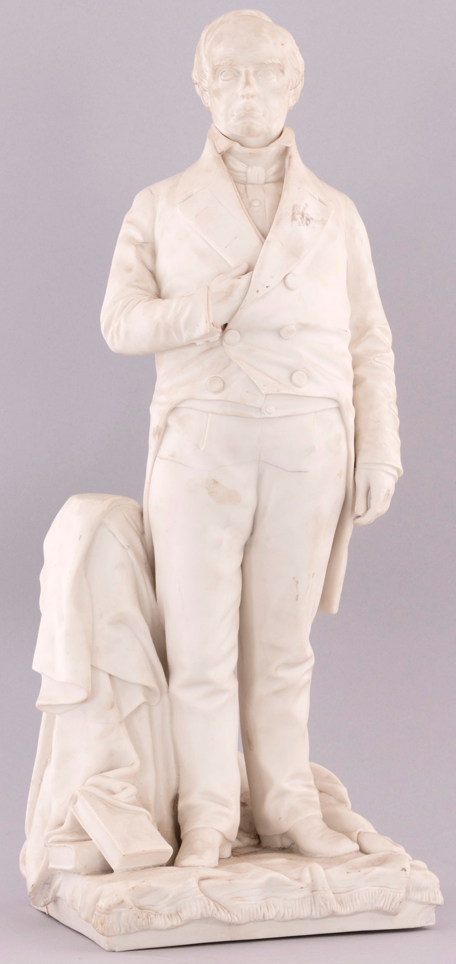 DANIEL WEBSTER FULL LENGTH PORTRAIT PARIAN WARE STATUE.: 25.5" tall, 8x9.5" base. Exceedingly rare G.W. Nichols parian ware after Thomas Ball's work of standing Daniel Webster. Extensive cracks affect base but are largely observed in display. Small chips to