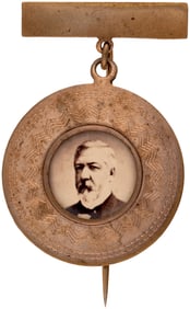 BLAINE STRIKING 1884 BRASS CHASED BORDER PORTRAIT UNDER GLASS BADGE.