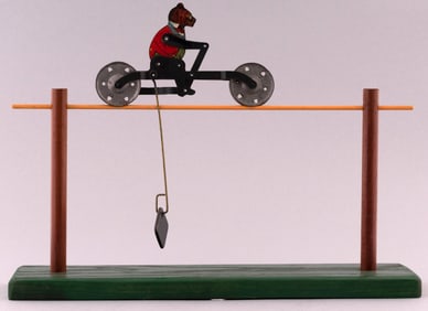 "HUSTLING TEDDY" ROOSEVELT BEAR ON BICYCLE 1910 STRING TOY.