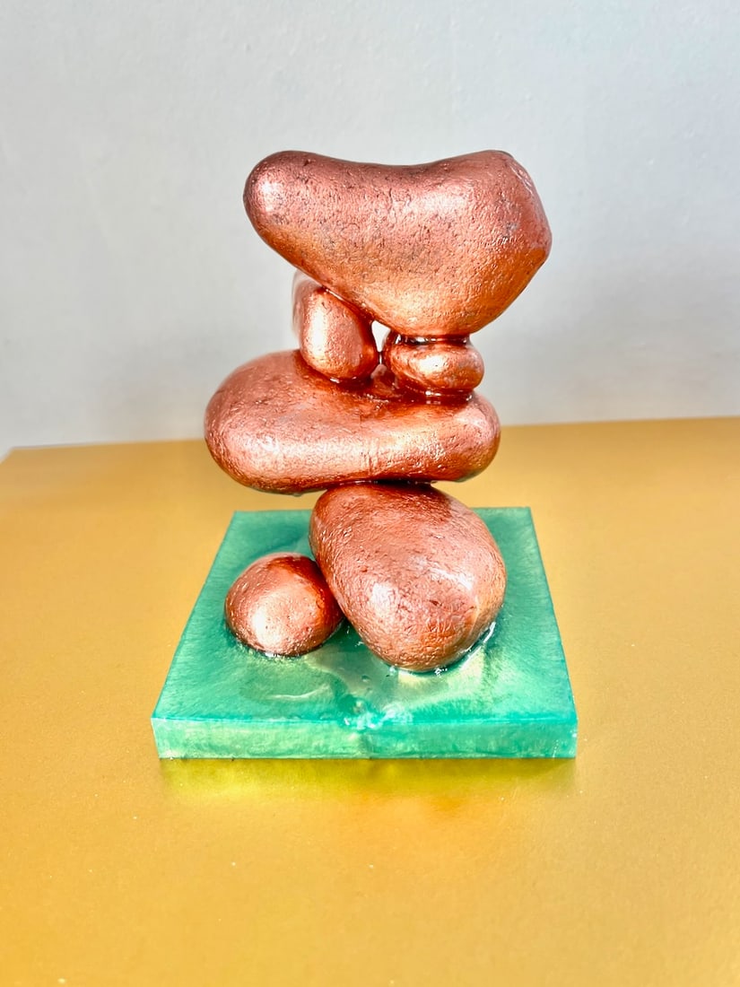 Love is in the Air By Stephanie Fuller (Burns) Sculpture - Irish Beach Pebbles, rose-gold guilt and: SHIPS FROM UK “Love is in the Air” is a tender, uplifting sculpture where organic forms in soft rose-gold seem to float above a tranquil translucent green base. The stones appear to lean towar