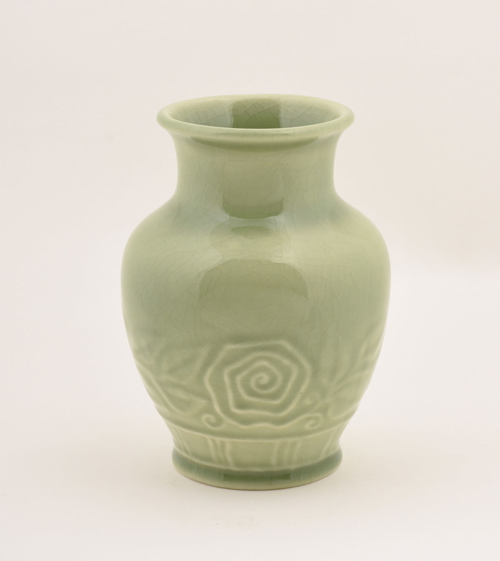 Rookwood Pottery Production Vase: with a floral design covered in a celadon high glaze. 1946. 6 1/4 inches high, 4 3/4 inches diameter. Impressed Rookwood Pottery Flame mark, XLVI.