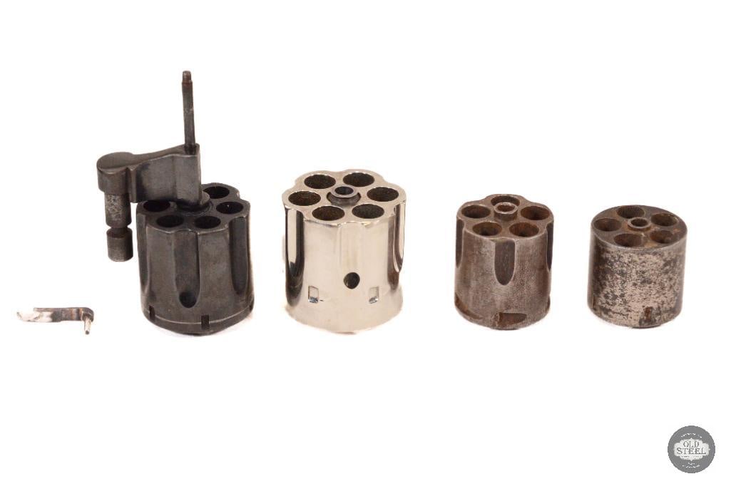 Various Revolver Cylinders .38 Cal - .45 Cal: 4 cylinders, unmarked. The blued cylinder with a yoke has a serial number matching to Colt's archives for a Police Positive Special in 38 SPL. The Nickel plated cylinder appears to be a for a Colt sin