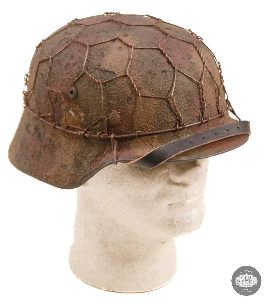 M35 German WWII Stahlhelm With Chicken Wire & Camo Paint: Original German M35 steel helmet shell, professionally refurbished with new liner, paint, and applied chicken wire with camouflage finish. Refurbishment presents a WWII-style field appearance while re
