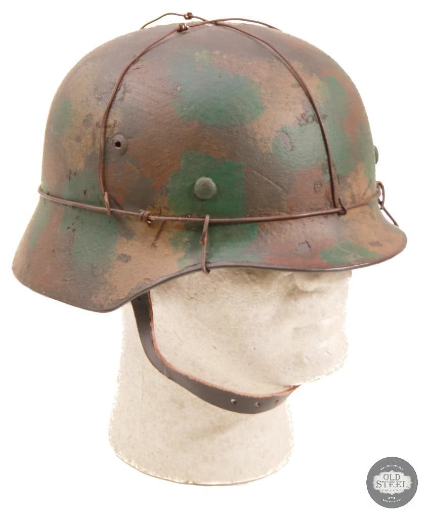 M40 German WWII Stahlhelm With Wire & Camo Paint: Original German M40 steel helmet shell, professionally refurbished with new liner, paint, and applied wire with camouflage finish. Refurbishment presents a WWII-style field appearance while retaining