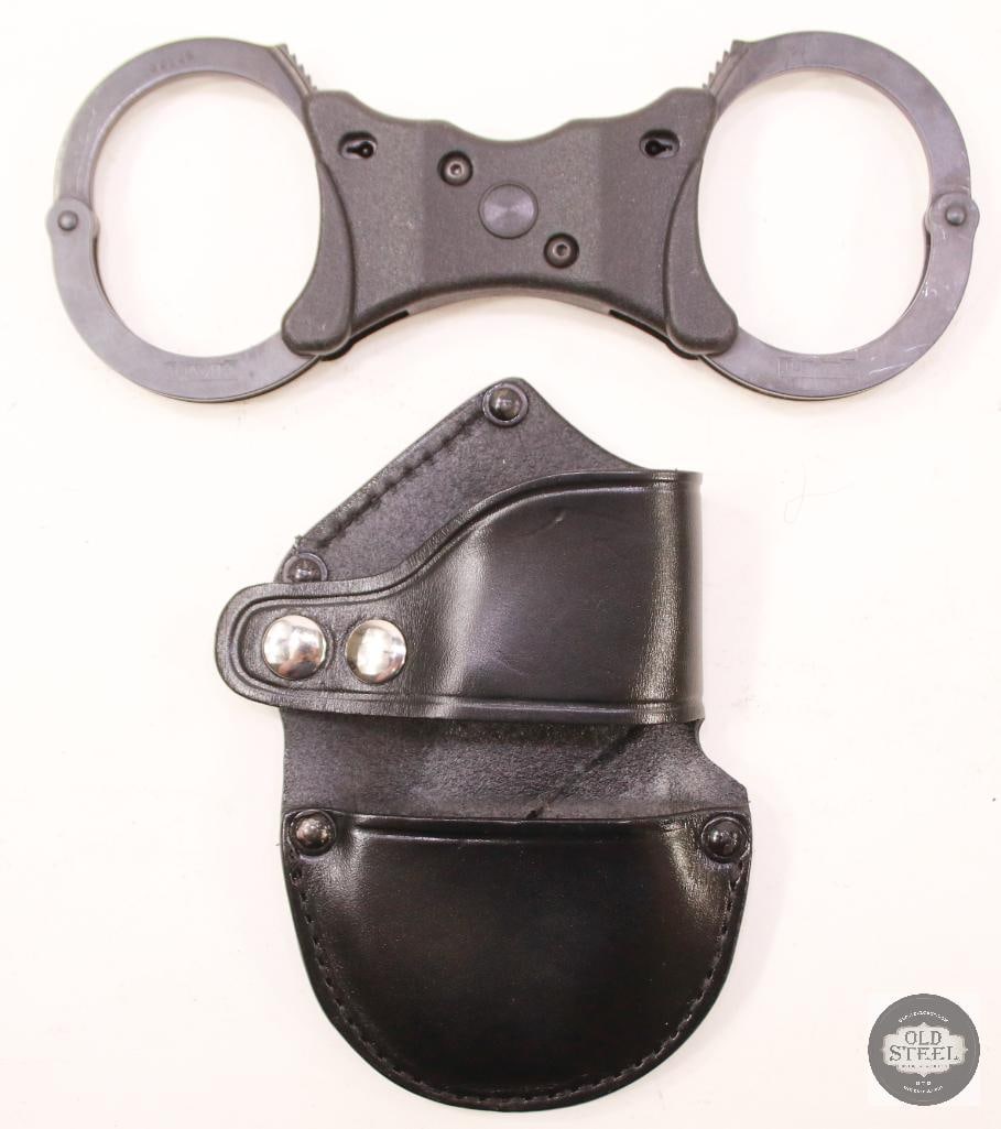 Non-Hinged Handcuffs With Leather Case: Non-hinged handcuffs accompanied by a leather carry case, key not included. Traditional chain-style restraint set intended for collection, display, or prop use. THIS ITEM IS AS PICTURED