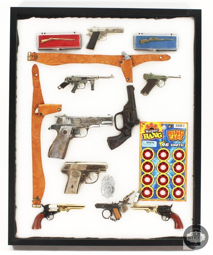 Wall Display Featuring Various Miniature Toy Guns and Caps and Other 17x21x3: Wall Display Featuring Various Miniature Toy Guns and Caps and Other 17x21x3 THIS ITEM IS AS PICTURED WITH NO FURTHER ATTACHMENTS. ALL SALES ARE FINAL. PLEASE REFER TO THE AUCTION