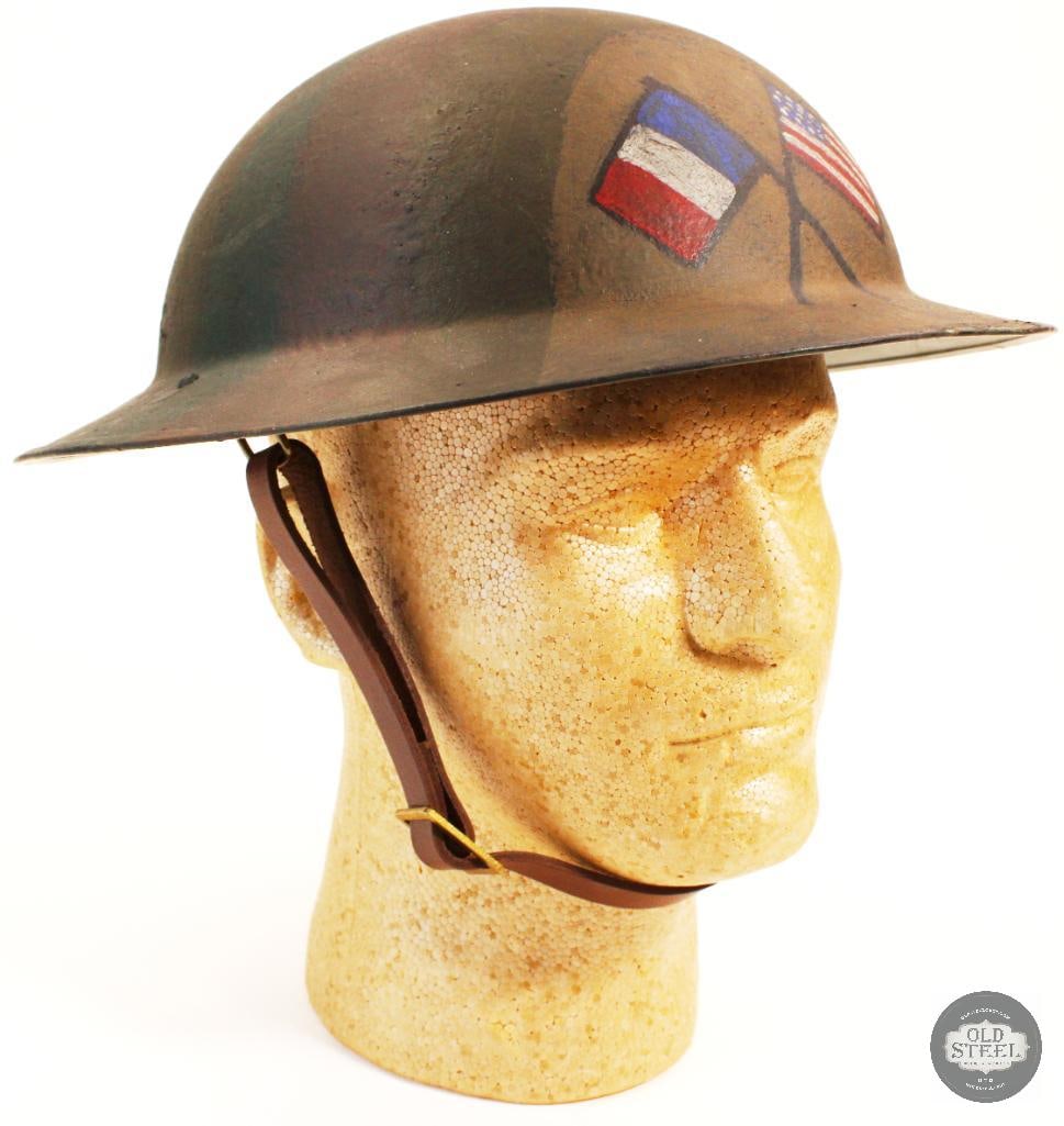 1917 Brodie Helmet Original shell: US M1917 Brodie steel helmet. Solid rivet construction, new made liner and chinstrap. The shell is original with a period correct style camouflage paint replicating those seen in theater. 