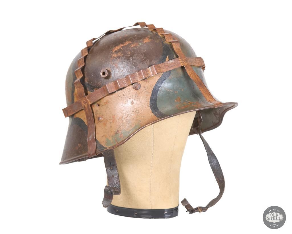 Original Interwar German M16 Helmet, Very Rare Early Paint, 3-Pad Liner, and Foliage Basket: This is an interwar German Model 1916 helmet, notable for its early features and survival of an original sheet-metal foliage basket attachment. Helmets of this type reflect the evolution of German hea