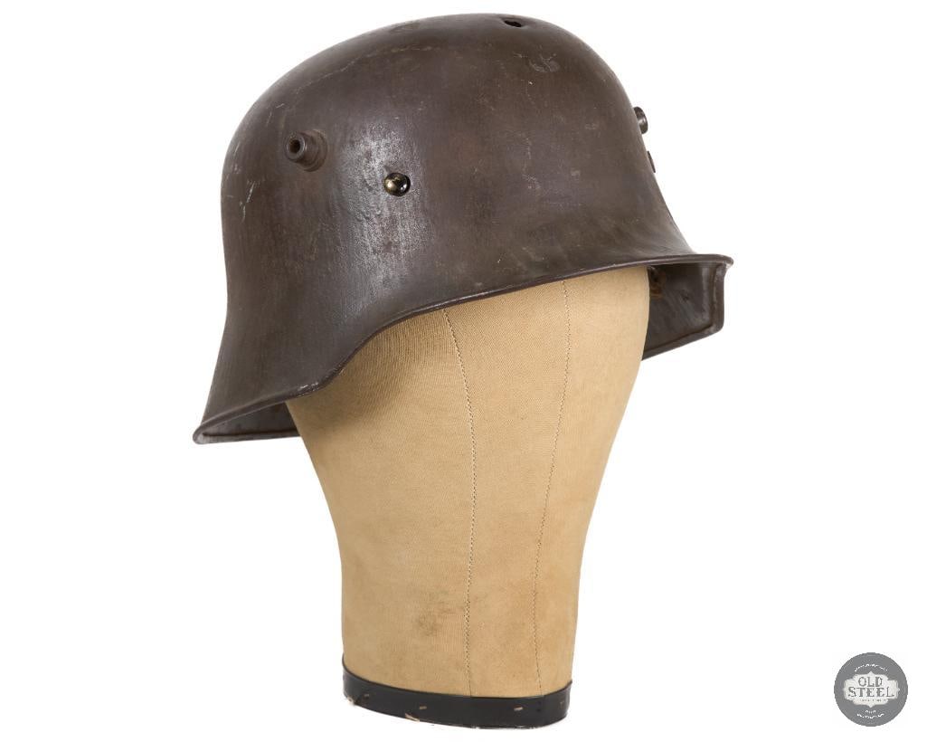 Battle Damaged M18 German WWI Helmet Shell - Head Shot: Original German WWI M18 helmet shell with headband. Bullet entry on forehead and lower back end exit. No chinstrap. Only visible marking is a faded K64 on the side and R1722 crisply marked on the inte