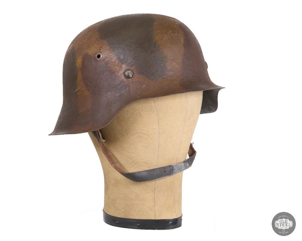 WWII German M42 Helmet with Camouflage Paint: This is an original M42 German helmet from WWII. Tri-color camouflage pattern is well protected and preserved. The leather of the liner is in great condition as is the chinstrap though it is a bit