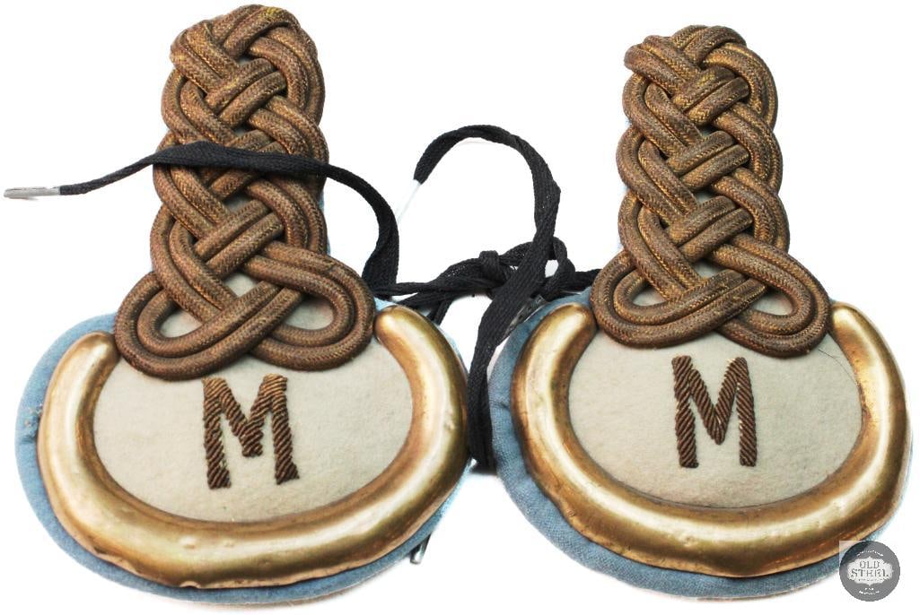 1880 Pattern Dress Knots: 1880 Pattern Dress Knots, typically worn by United States Army officers during the Indian Wars period, from 1880 to 1902. The insignia features metallic braiding with a prominent letter "M"