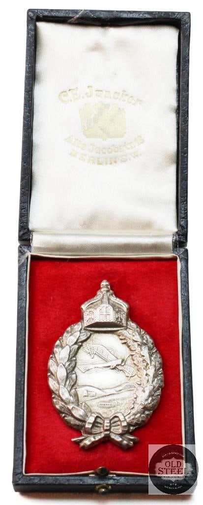 Original Prussian WWI Silver Pilot Badge by C.E. Juncker of Berlin with Original Box: Prussian WWI Pilot Badge Manufactured by C.E. Juncker of Berlin - Silver THIS ITEM IS AS PICTURED WITH NO FURTHER ATTACHMENTS. ALL SALES ARE FINAL. PL