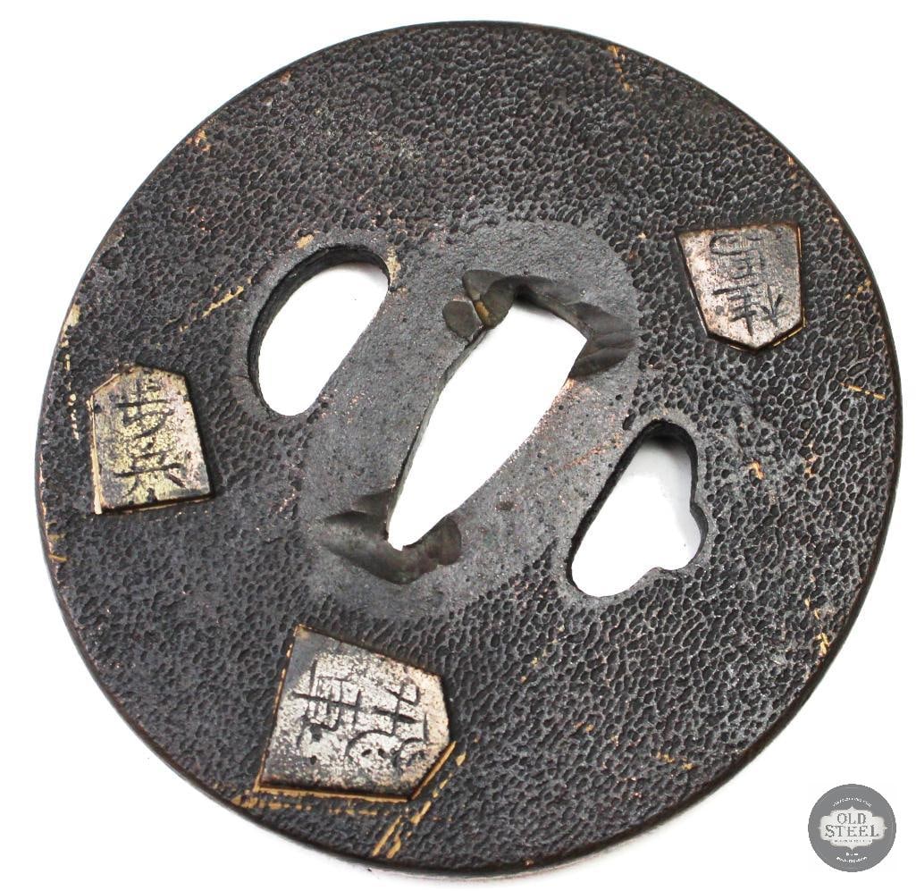 Original Japanese Iron Tsuba Sword Guard Traditional Fitting: Original Japanese iron tsuba sword guard constructed of iron with traditional design elements consistent with Japanese sword fittings. The piece shows age-related wear, patina, and handling marks