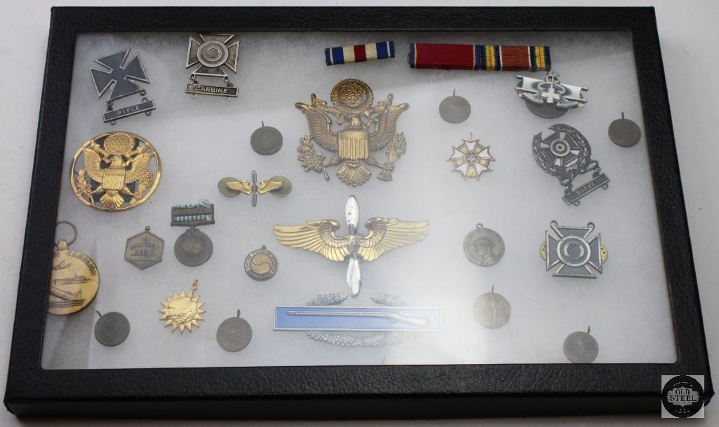 Collection of Various US Military Medals/Decorations: This collection features various US military medals/decorations, including marksman badges and aviation wings. It includes a Legion of Merit medal, a distinguished decoration often awarded to