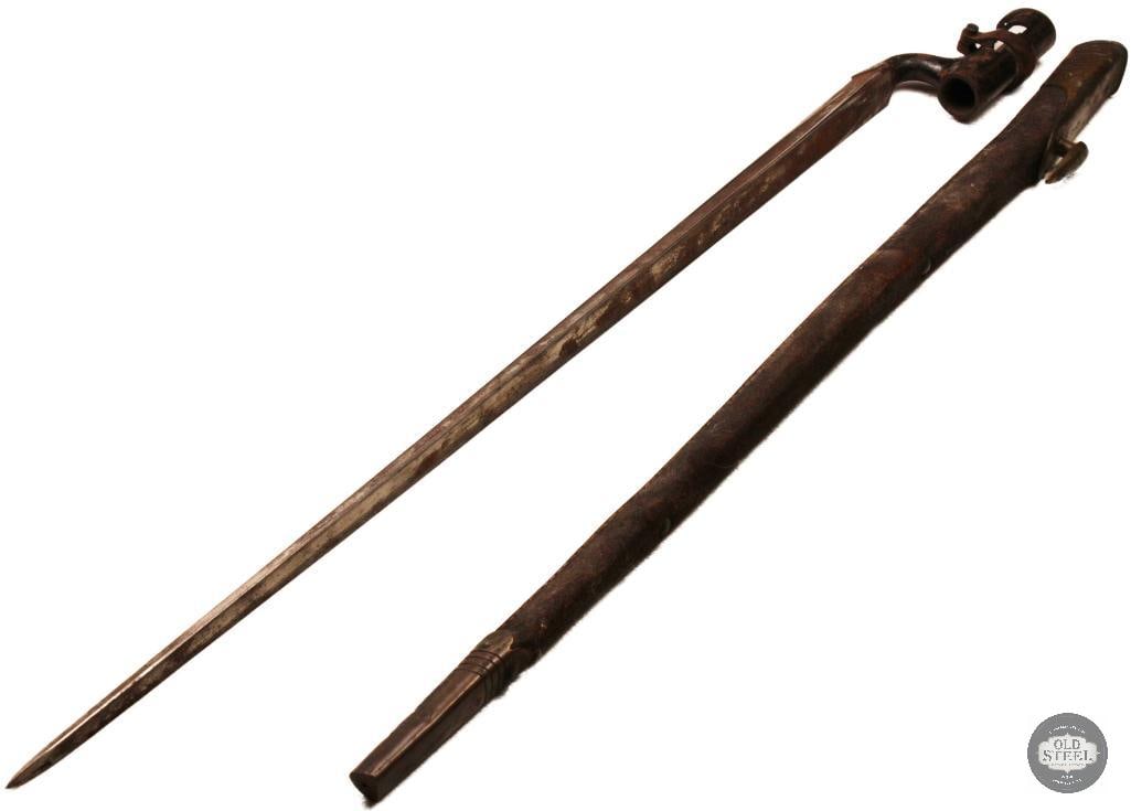British Tri-Edge Socket Bayonet w/ Scabbard Possibly Martini-Henry: British tri-edge socket bayonet complete with its scabbard. The bayonet features the classic triangular blade and socket mounting system associated with British military arms of the 19th century. It s