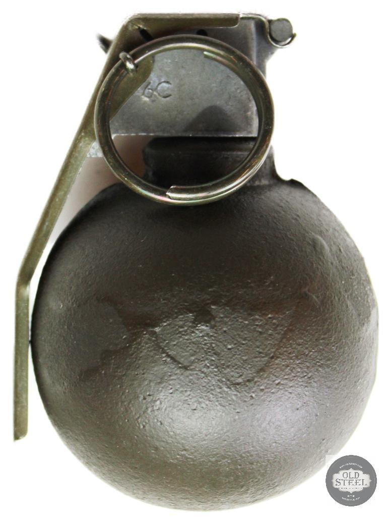 Inert M67 Fragmentation Grenade: This is an inert M67 fragmentation grenade commonly used as a display piece or conversation starter. It features a spherical body and a metallic safety lever ("spoon") with a pull ring and pin. Such