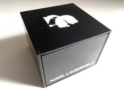 Montre KARL LAGERFELD: Montre en céramique blanche, boucle déployante, mouvement à quartz, dans son étui d'origine. Bon état, petites rayures et taches d'usage, pile à changer.