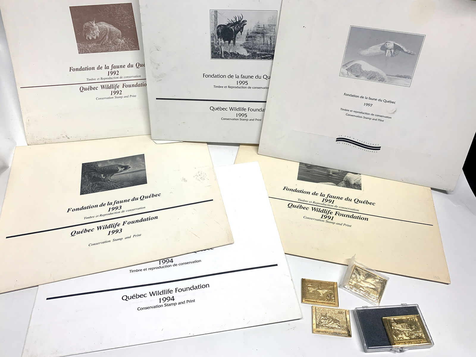 Collection faune Québec: Collection de timbres et impressions de la Fondation de la faune du Québec pour les années 1991-1992-1993-1994-1995-1997, certaines signées, avec 4 plaques en métal doré.