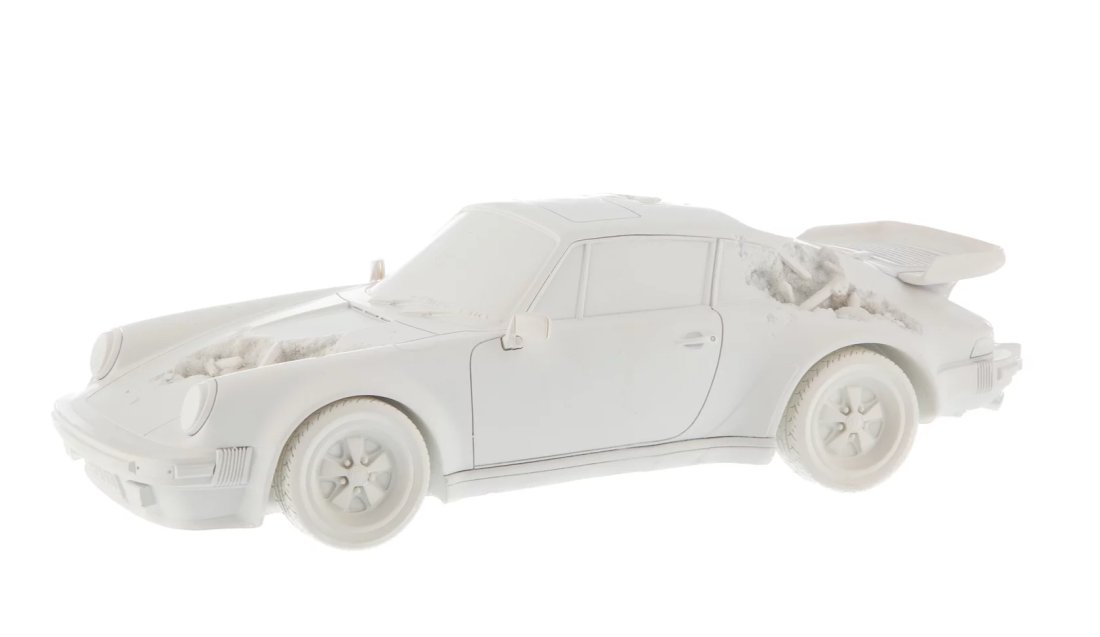 Daniel Arsham: Eroded Porsche 911 Turbo (930) White , 2020: Eroded Porsche 911 Turbo 930 (Sculpture Edition) (White), 2020. 3 1/2 × 12 1/2 in | 8.9 × 31.8 cm. Hydrostone and quartz crystals. Provenance: Heritage Auctions, Jessica Leigh Collection, Bedford Ar