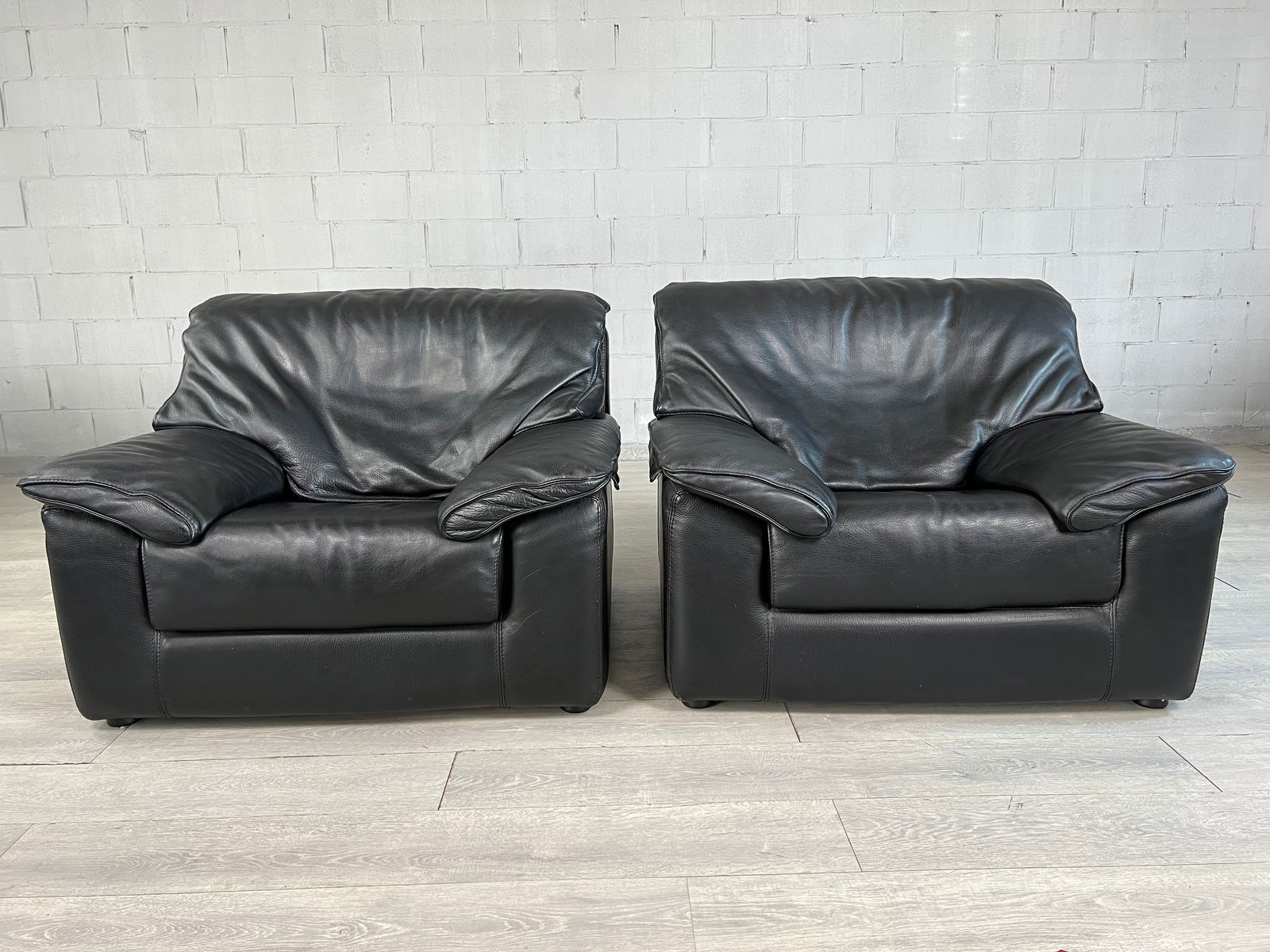 PAIR OF ITALIAN LEATHER ARCMHAIRS BY GIACOMO TOSCANI: Pair of Italian Leather armchairs by Giacomo Toscani with removable cushions and armrests, attached with zipper. Stamped under cishion. Dimensions: H 33" x W 41.5" x SD 19" x SH 16.5"