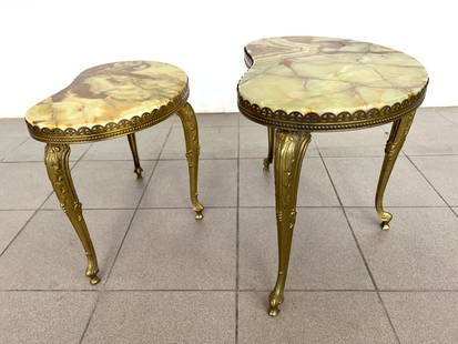 (2) HOLLYWOOD REGENCY ONYX NESTING TABLES: Dimensions: H 15.5” x W 18.5” x D 11” / H 17.5” x W 22.5” x D 13.5”. Set of 2 Italian Hollywood Regency nesting tables with brass ornate legs and onyx top. Flat rat