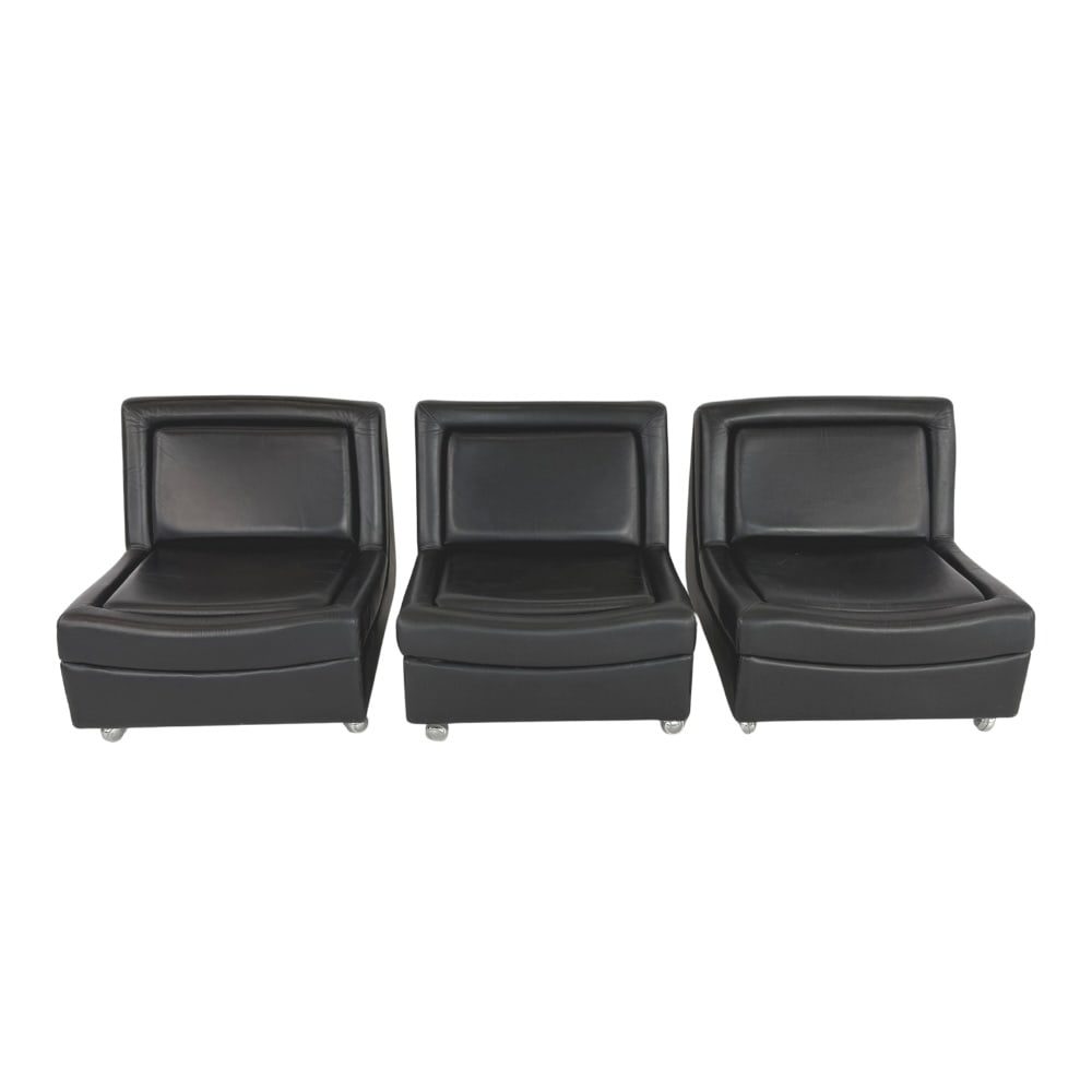 (3) ITALIAN 1970s LOUNGE CHAIRS MANNER OF JACQUES CHARPENTIER: Dimensions: H 28.3” x W 28” x D 31.5” x SH 15.5”. Vintage set of 3 Italian black leather lounge chairs with legs on wheels manner of Jacques Charpentier.