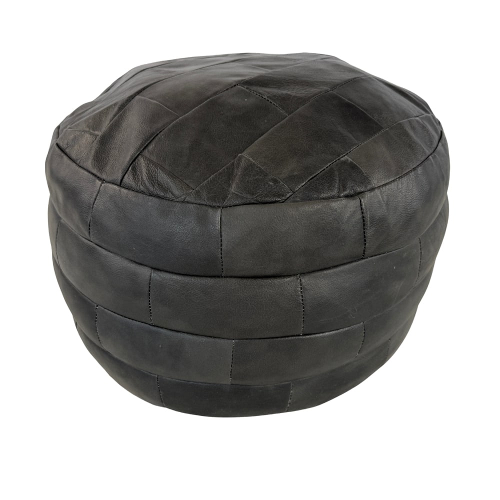 DE SEDE BLACK LEATHER POUF: Dimensions: H 15.5” x W 19”. De Sede black leather patchwork pouf.