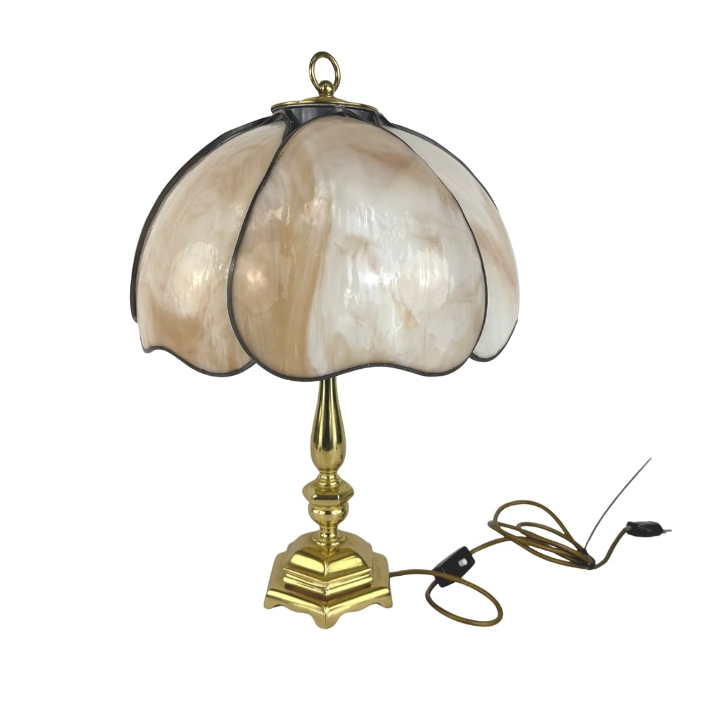 TIFFANY STYLE TABLE LAMP: Dimensions: H 23.5” x W 17.5” (lampshade). Tiffany style table lamp with gold toned base and beige glass lampshade.
