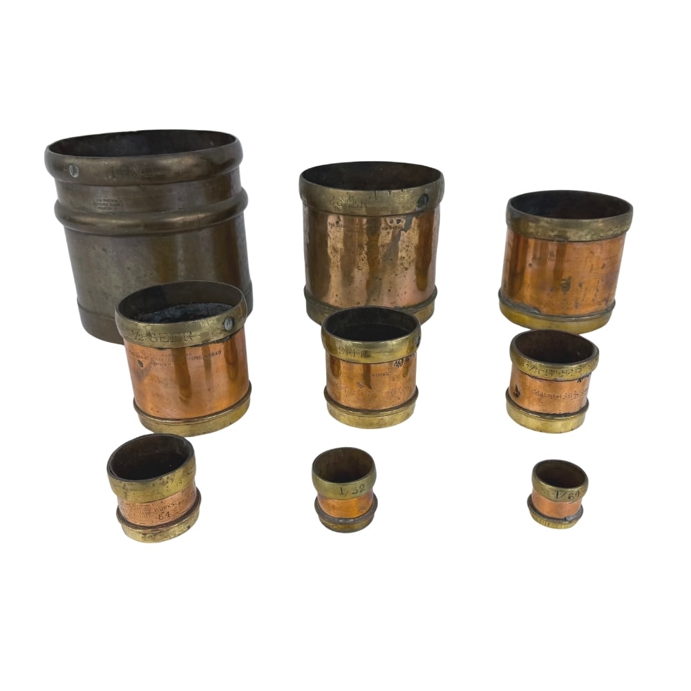 (9) ORIENTAL METAL PRESSING WORKS BOMBAY GRAIN MEASURES: Dimensions: H 7”/5.7”/5”/3”. Set of 9 Antique Oriental Metal Pressing Works of Bombay Indian copper and brass grain measures.