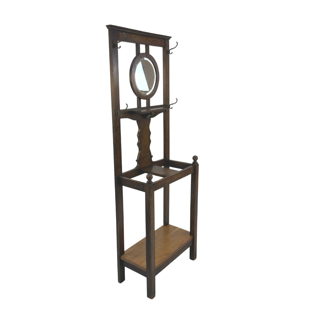 ANTIQUE OAK HALL STAND: Dimensions: H 69” x W 23” x D 12”. Antique oak hall stand with 4 double coat hooks, round central mirror and areas for umbrellas.