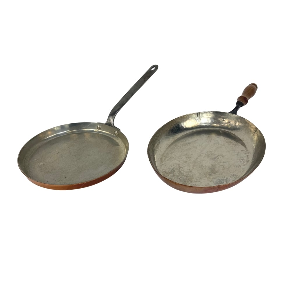 ANTIQUE COPPER PANS, A PAIR: Dimensions: W 21”/19.5” x D 9.7”/9.5”. Pair of French and Swiss Antique copper pans with wrought iron handles. One of the pans marked Stockli Netstal.