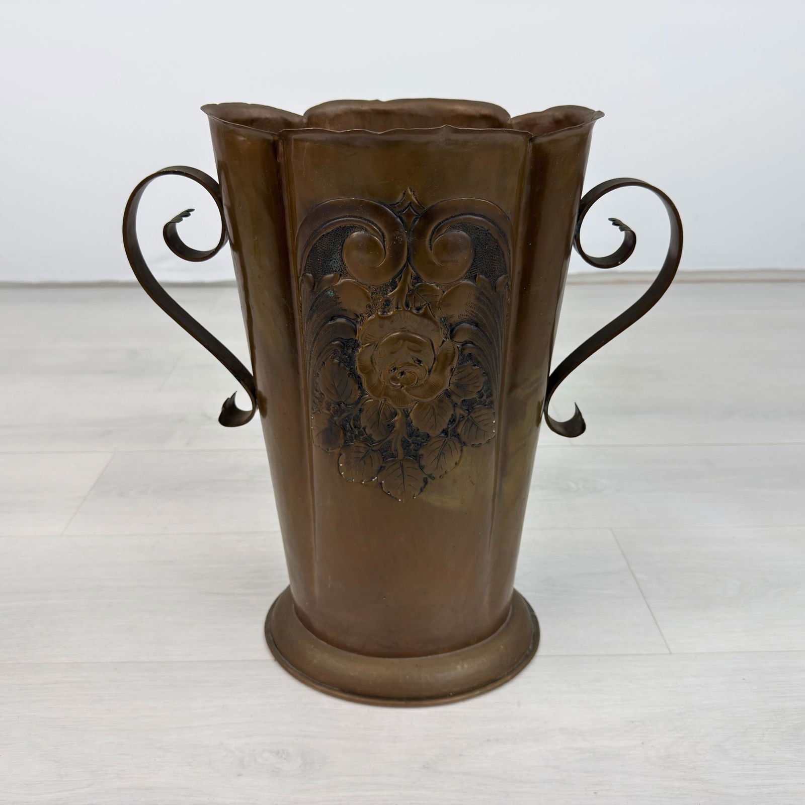 ANTIQUE COPPER VASE: Dimensions: H 17.5” x W 10.5”. Antique copper vase with two handles and floral pattern on both sides.