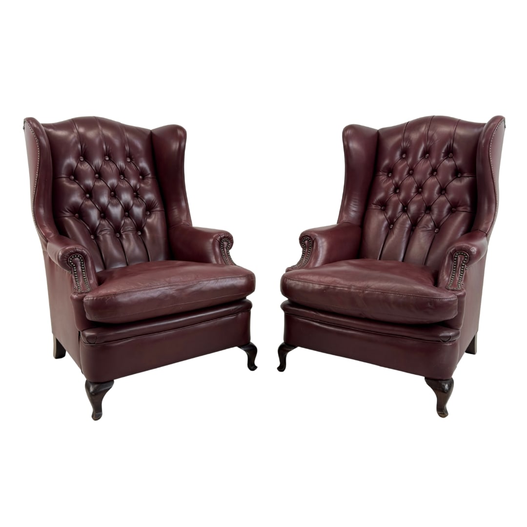 CHESTERFIELD WINGBACK ARMCHAIRS, A PAIR: Dimensions: H 45” x W 31” x D 35” x SH 20”. Pair of Vintage burgundy leather wingback armchairs with loose padded cushions.