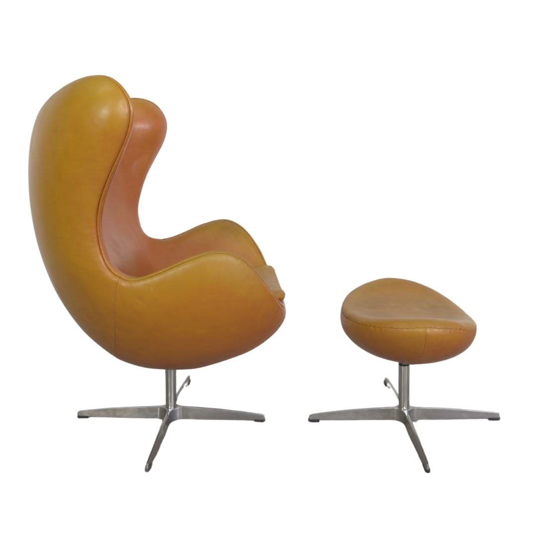 EGG CHAIR AND OTTOMAN AFTER ARNE JACOBSEN: Dimensions: H 42” x W 32” x SD 19.5” x SH 20”. Vintage set of egg chair and ottoman after Arne Jacobsen for Fritz Hansen, upholstered in cognac leather. Dimensions" (ottoman)