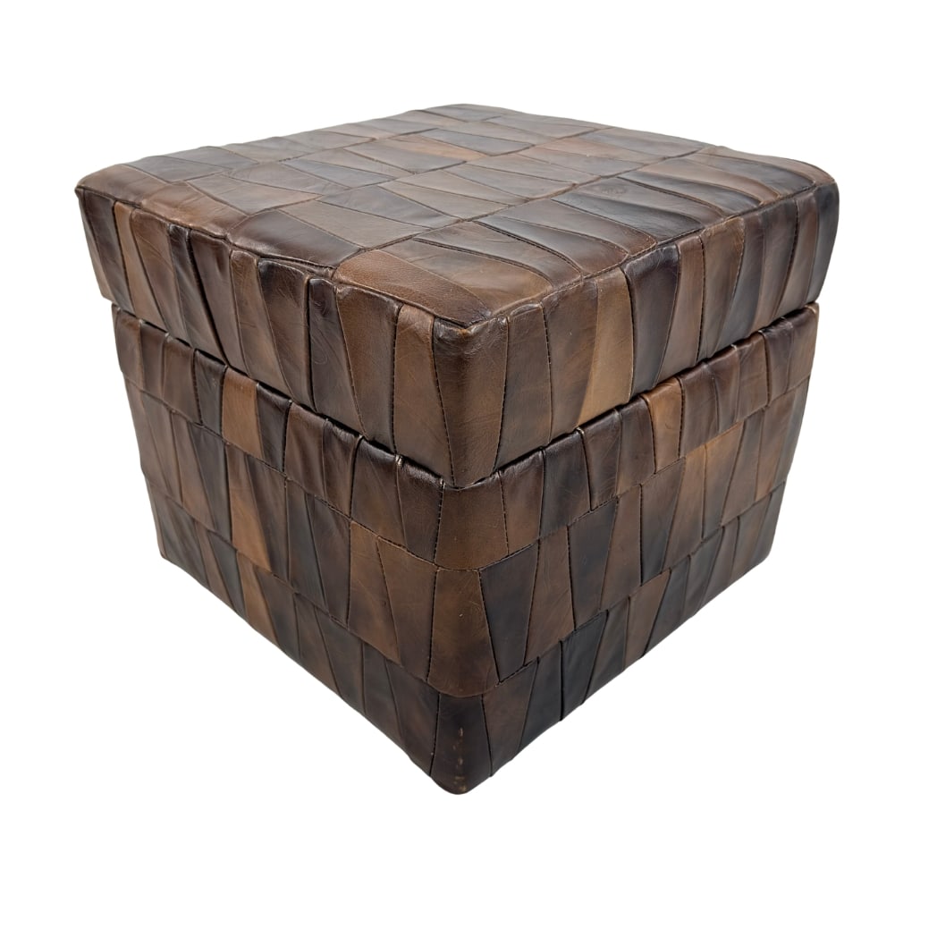 DE SEDE LEATHER STORAGE POUF: Dimensions: H 14” x W 16.5” x D 16.5”. Vintage brown leather patchwork storage pouf from De Sede.