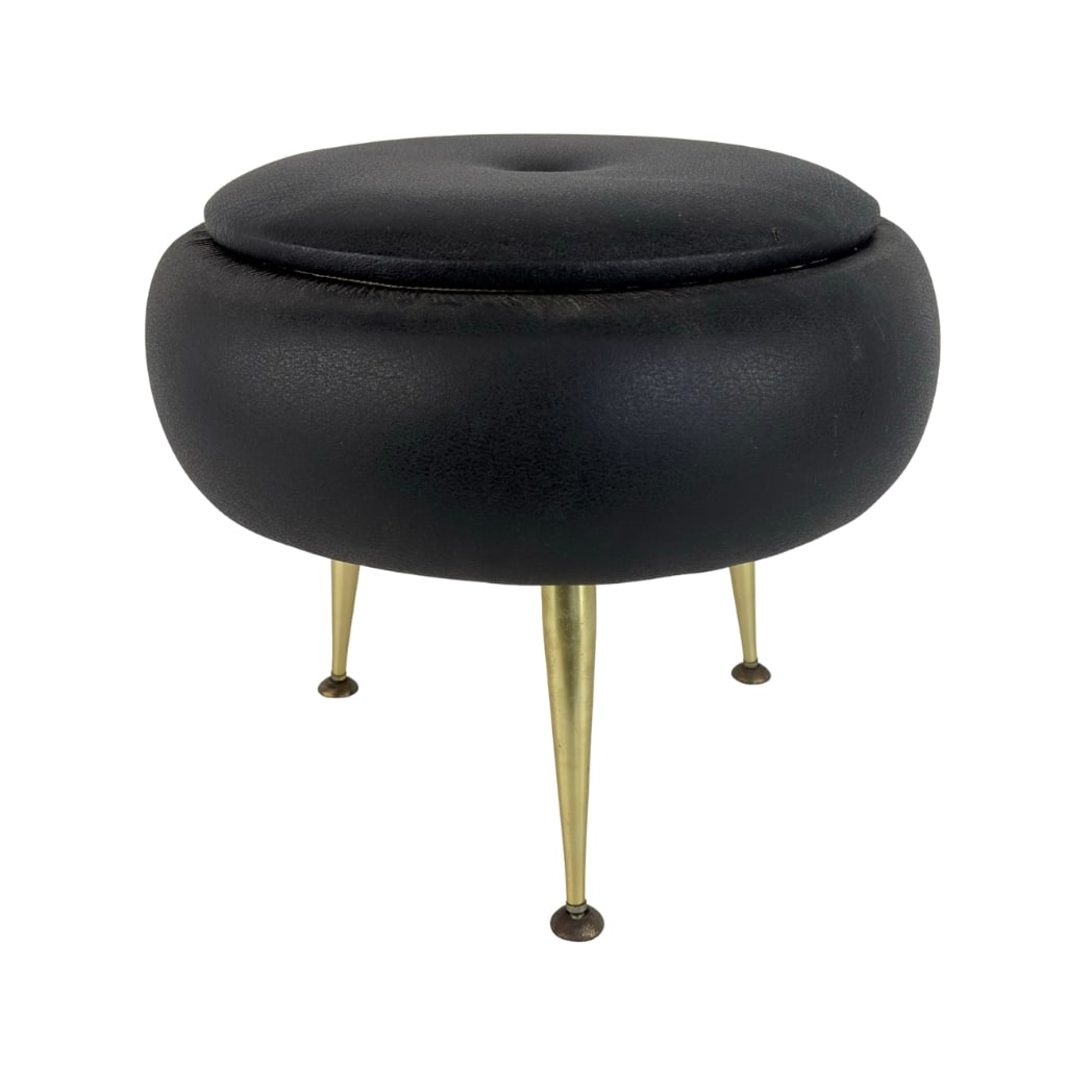 VINTAGE FAUX LEATHER STORAGE POUF: Dimensions: H 16” x W 18”. Vintage Italian black faux leather storage pouf with brass legs.