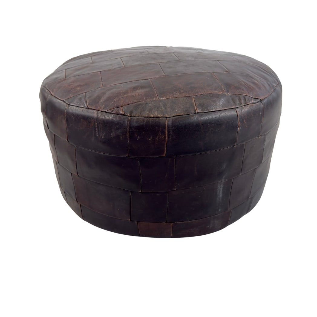 DE SEDE LEATHER POUF: Dimensions: H 15” x W 22.7”. Vintage brown leather patchwork pouf from De Sede.