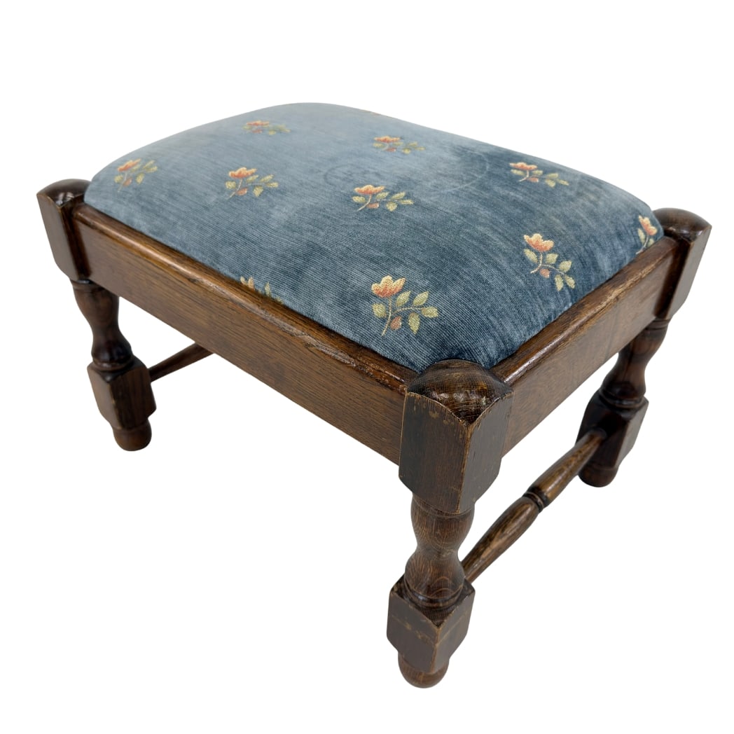 VINTAGE FRENCH FOOTSTOOL: Dimensions: H 16.7” x W 21.3” x D 15.5”. Vintage French footstool with dark wood frame with turned legs and original blue floral upholstered seat.