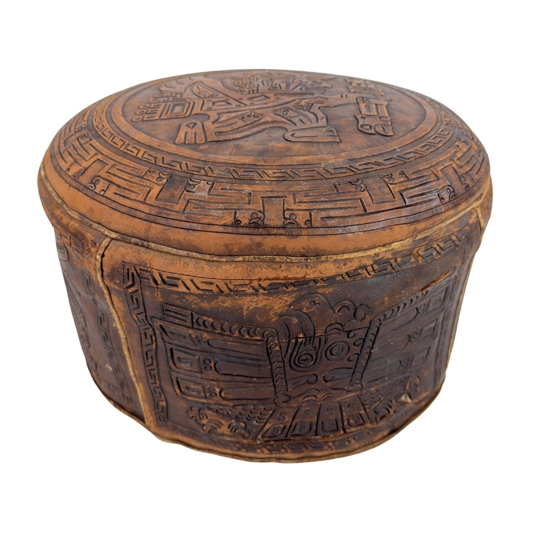 ANGEL PAZMINO LEATHER POUF: Dimensions: H 11” x W 15”. Vintage carved leather pouf in the Mayan style designed by Angel Pazmino, Ecuador 1960s.