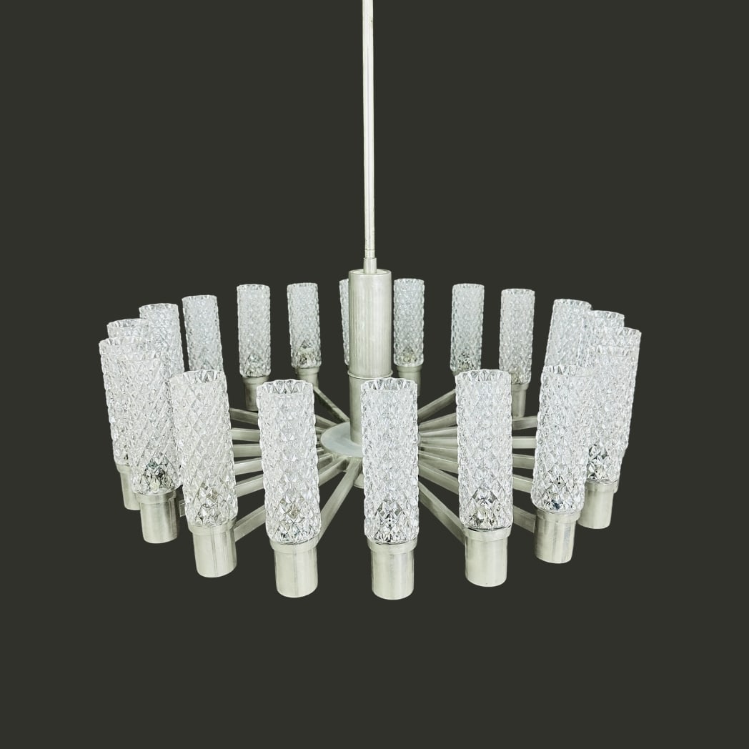 SPACE AGE CHANDELIER MANNER OF HILLEBRAND: Dimensions: H 31” x W 28”. 18 point Vintage Space Age chandelier manner of Hillebrand with cylindrical textured glass shades.