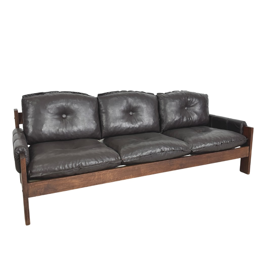 THREE SEATER SOFA MANNER OF SERGIO RODRIGUES: Dimensions: H 29” x W 77.5” x D 29.5” x SH 16”. Vintage three seater sofa in dark brown leather and wood manner of Sergio Rodrigues.