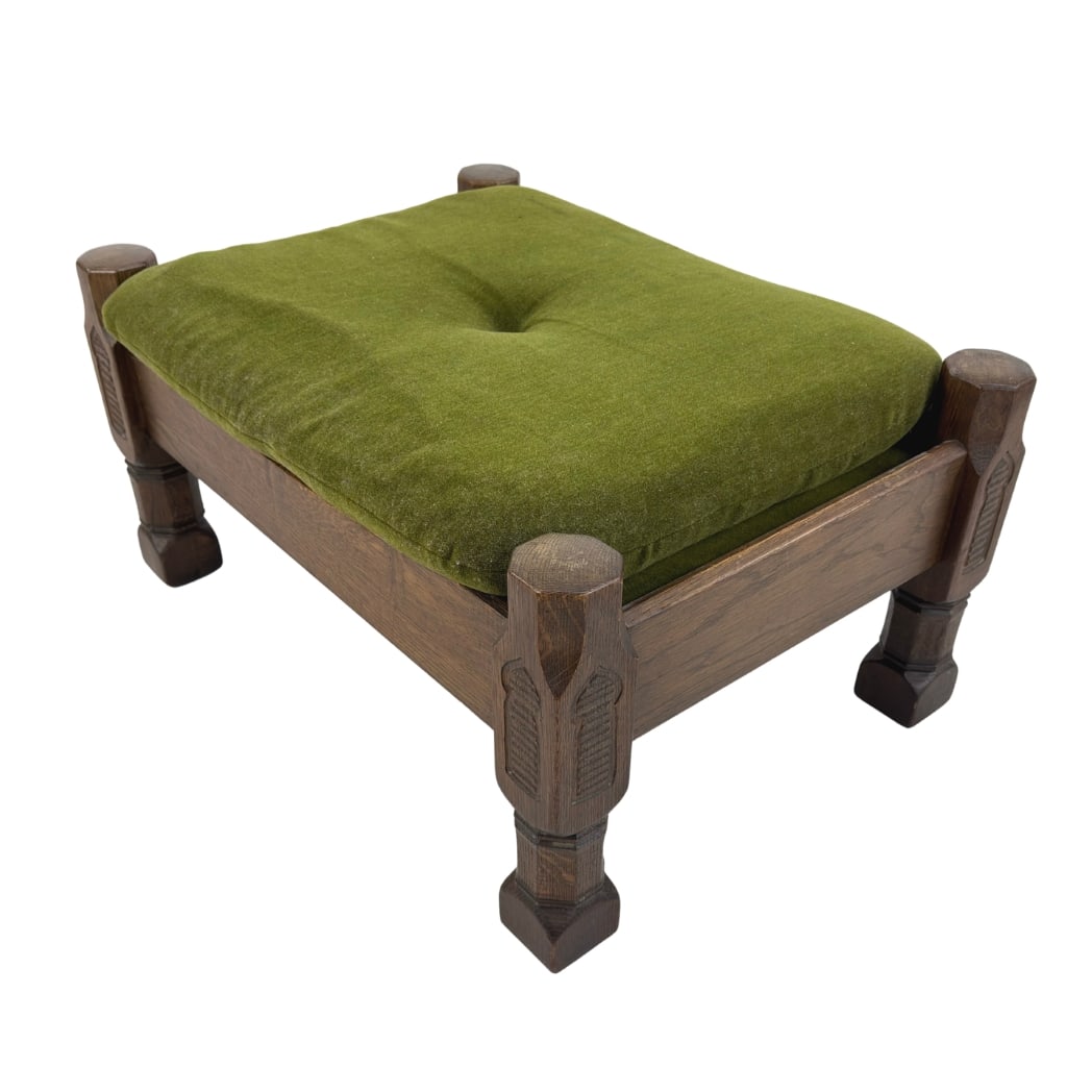BRUTALIST OAK FOOTSTOOL: Dimensions: H 15.5” x W 29” x D 20.7”. Vintage Brutalist carved oak footstool with original green upholstery.