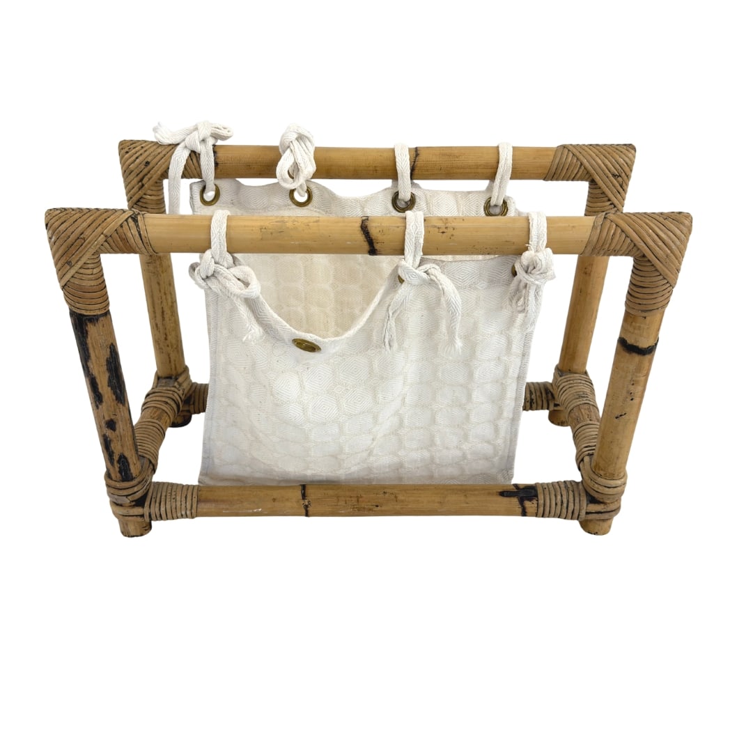 BAMBOO AND RATTAN MAGAZINE RACK: Dimensions: H 13.3” x W 20” x D 8.5”. Vintage bamboo and rattan magazine rack with white fabric sling.