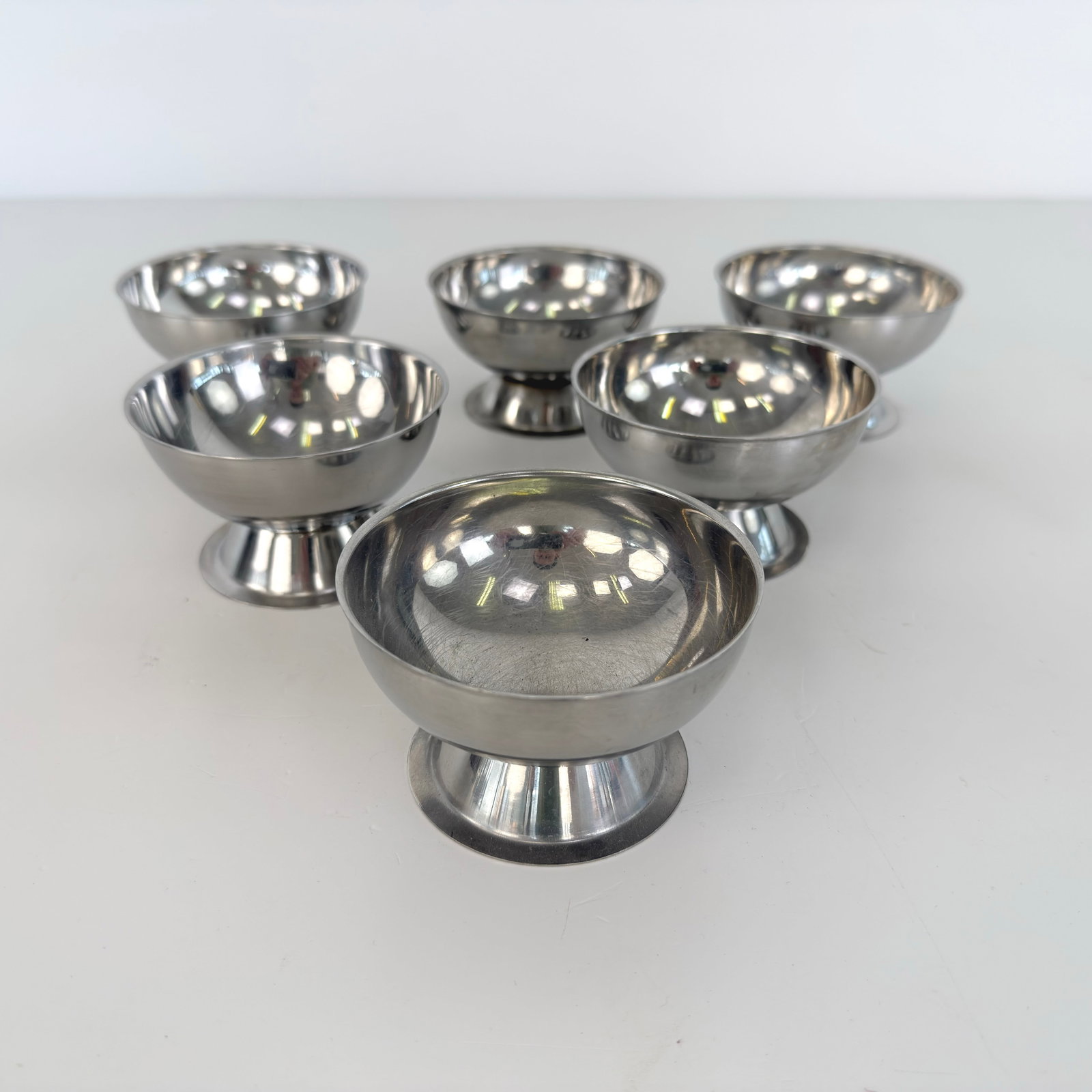 (6) VINTAGE ICE CREAM CUPS: Dimensions: H 2.5” x W 3.5”. Set of 6 Vintage stainless steel ice cream cups.